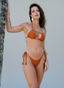 Woman wearing a brown bikini against a neutral background